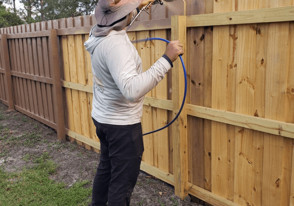 A Fernwright installer fastening pickets to a finished cedar fence