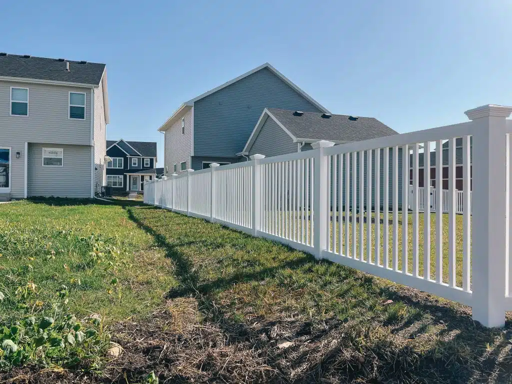 White vinyl picket fence in a residential yard