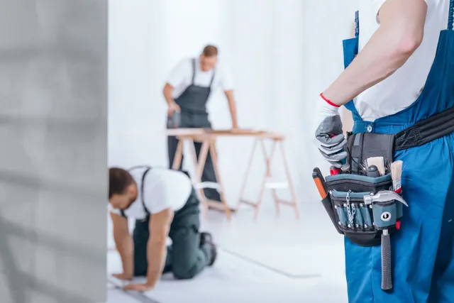 Bellamont handyman with tool belt and crew working in background